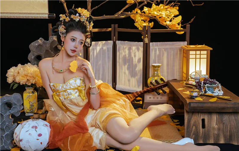 奈汐酱穿金色礼服坐在木桌和黄色花饰旁 奈汐酱穿金色礼服坐在木桌和黄色花饰旁