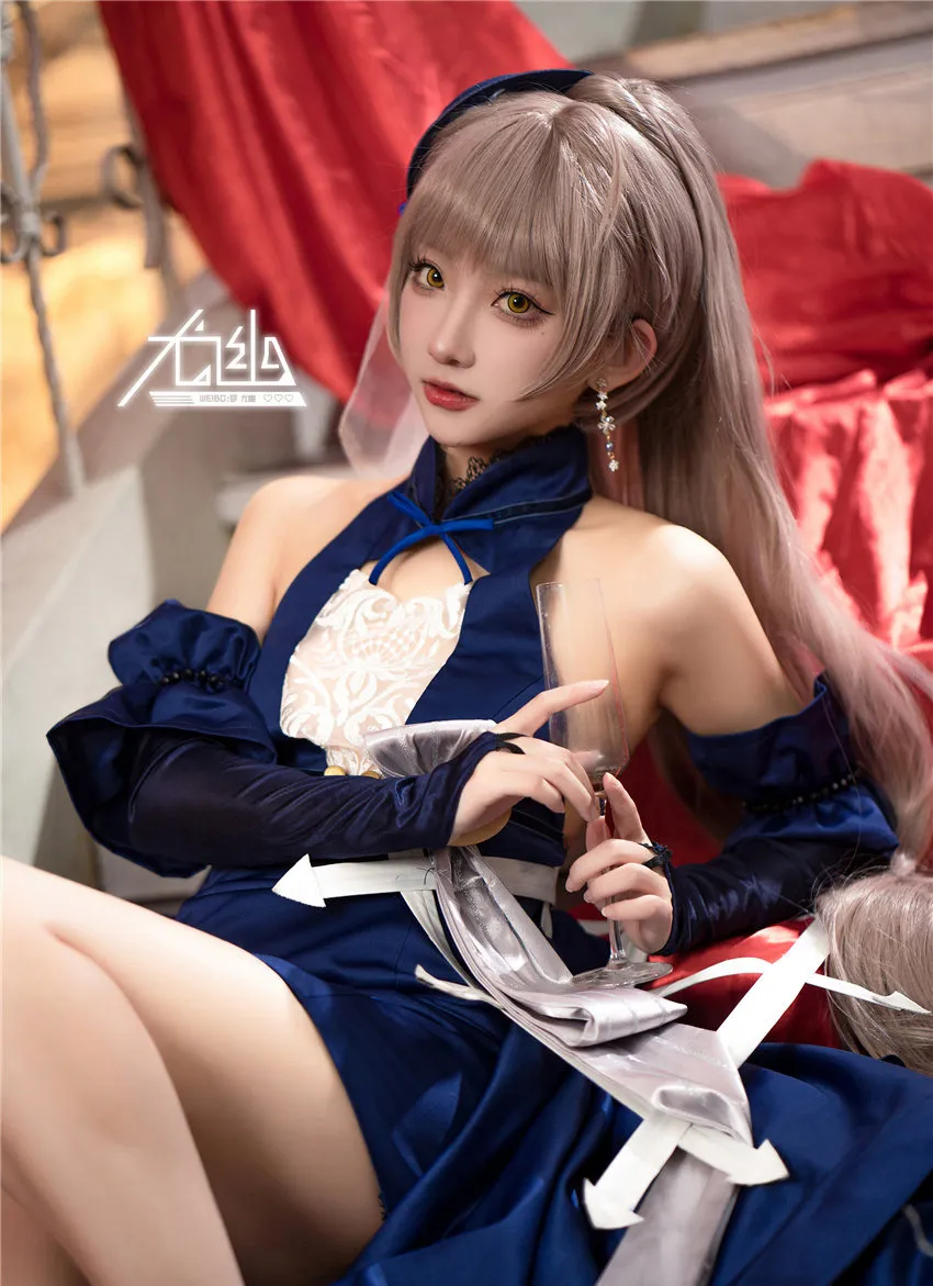 尤幽蓝色礼服手持玻璃杯的近景 尤幽蓝色礼服手持玻璃杯的近景