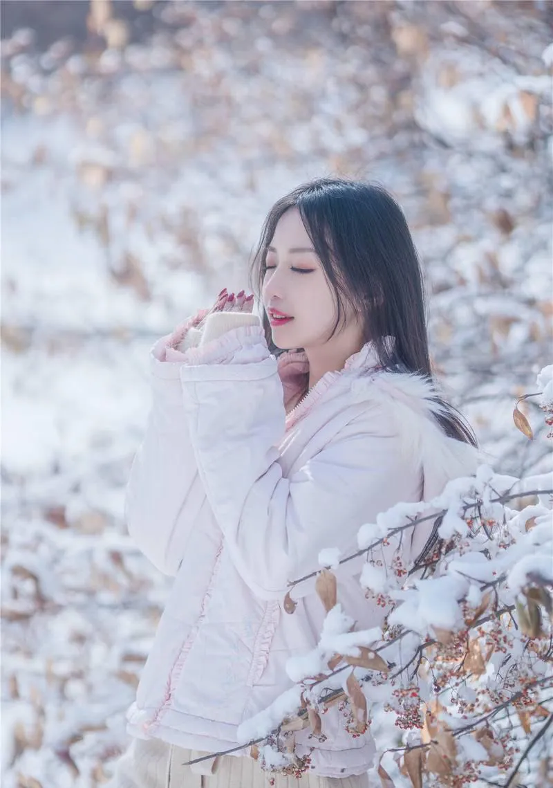 小鹿鹿深色长发穿浅色外套,置于带雪枝条前的近景 小鹿鹿深色长发穿浅色外套,置于带雪枝条前的近景
